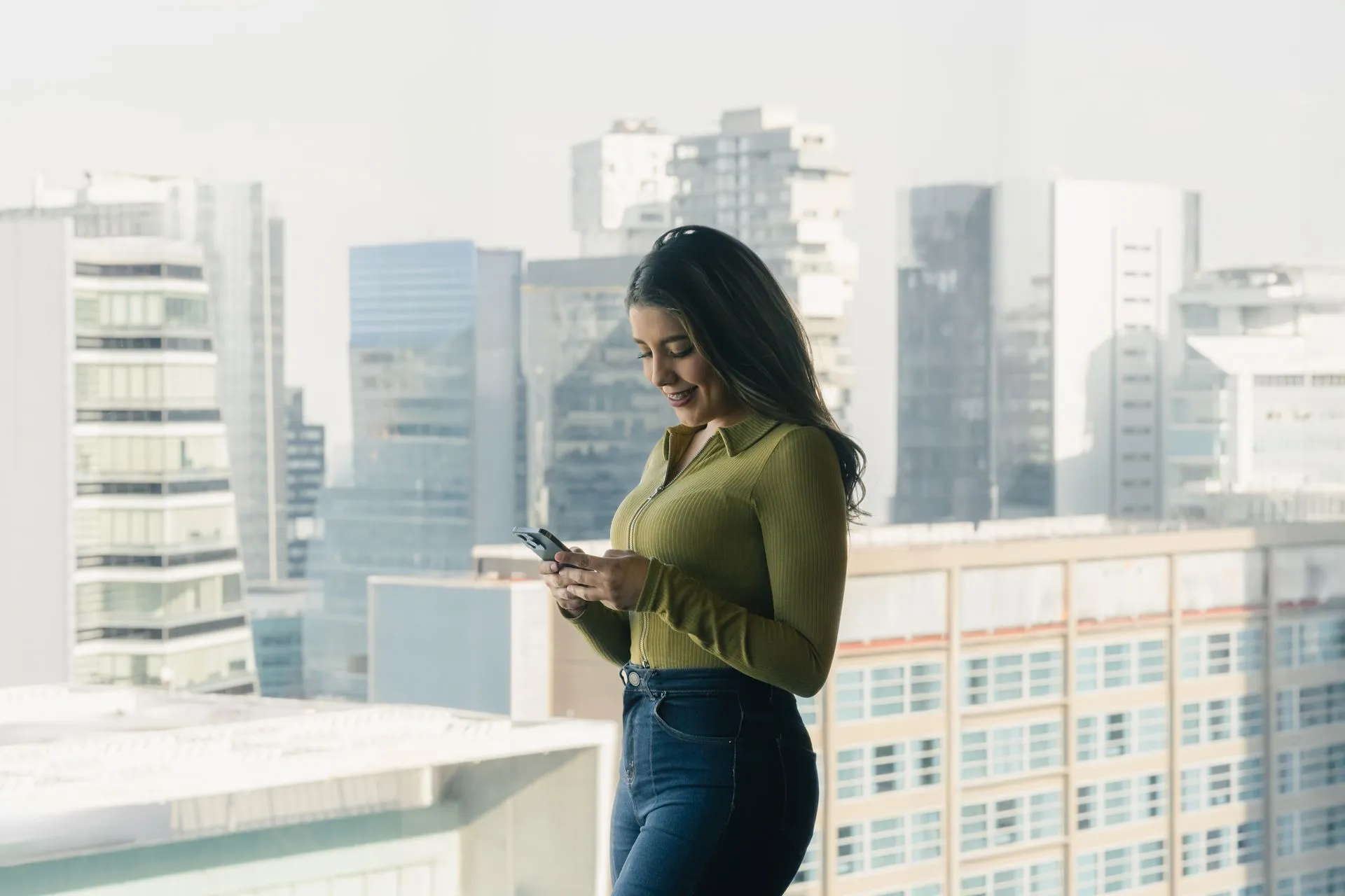 A woman checking her phone while standing in an office
